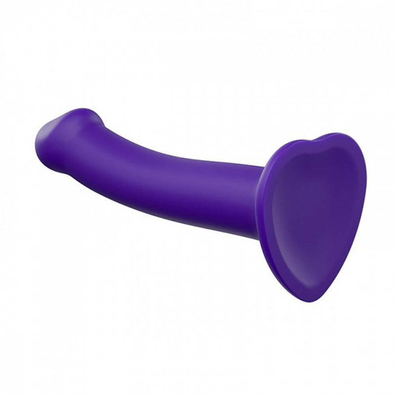 The Strap-on-Me Bendable Dual-Density Dildo faces away from camera to show the heart-shaped flared base. You can see that underneath the dildo base is slightly concave. | Kinkly Shop