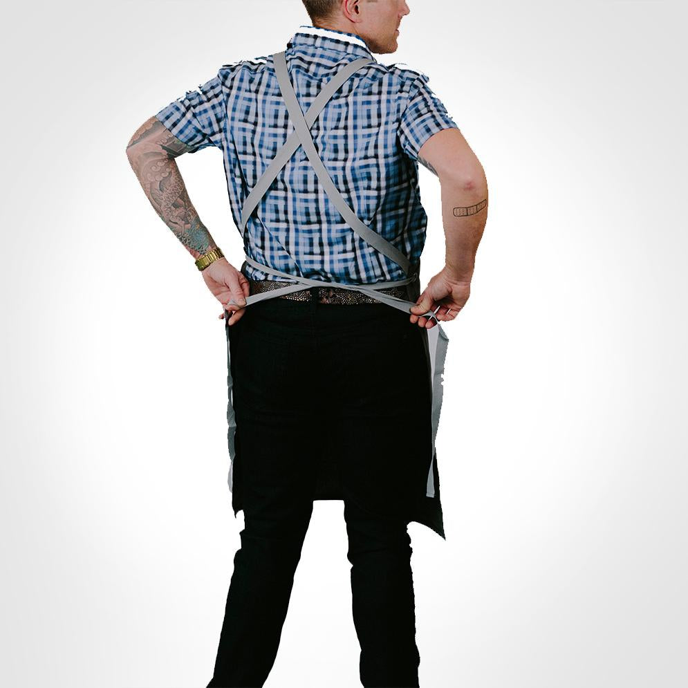 A person ties the I Rub My Own Meat Apron behind their back to show the size versatility | Kinkly Shop