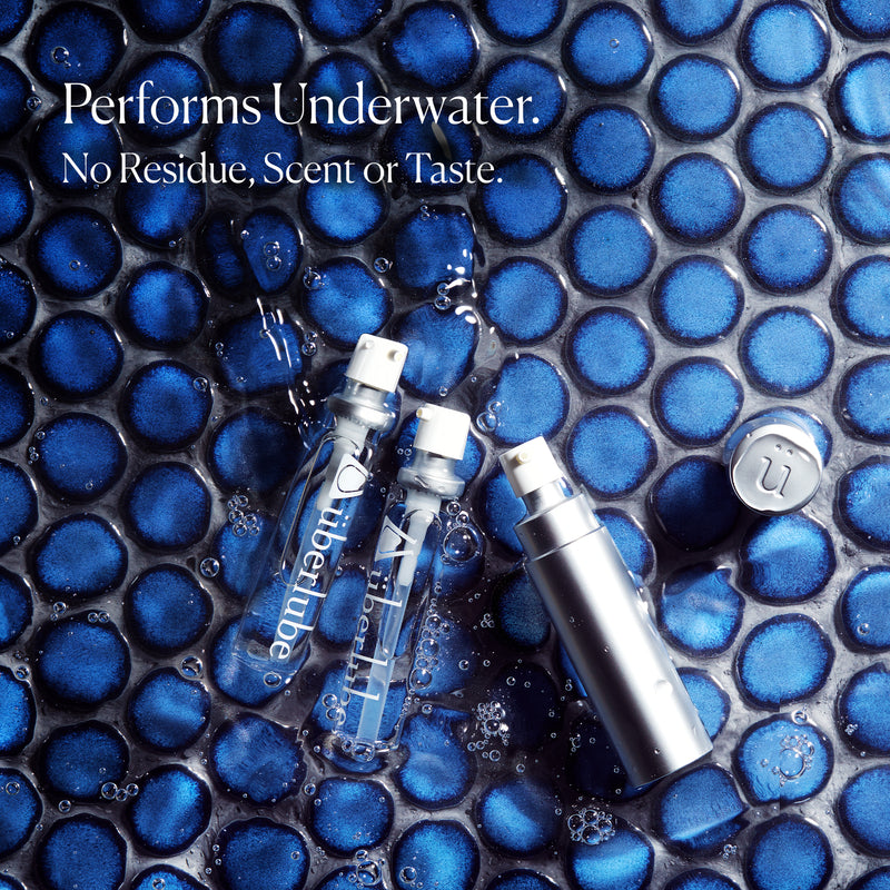 Überlube Good-to-Go Travel Size Lube bottles are laying on a blue tile that's filled with moving water. Words on the image read "Performs underwate. No residue, scent, or taste." | Kinkly Shop
