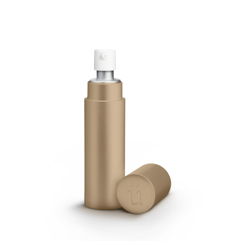 Überlube Good-to-Go Travel Size Lube in Gold. The image shows the opaque design of the outer case with the pump-top of the lube bottle sticking out from inside the case. The lid (with an embedded "U" on top) is sitting next to the case. | Kinkly Shop