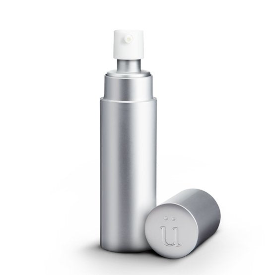 Überlube Good-to-Go Travel Size Lube in Silver. You can see the opaque design of the outer case with the pump-top of the lube bottle sticking out from inside the case. The lid (with an embedded "U" on top) is sitting next to the case. | Kinkly Shop