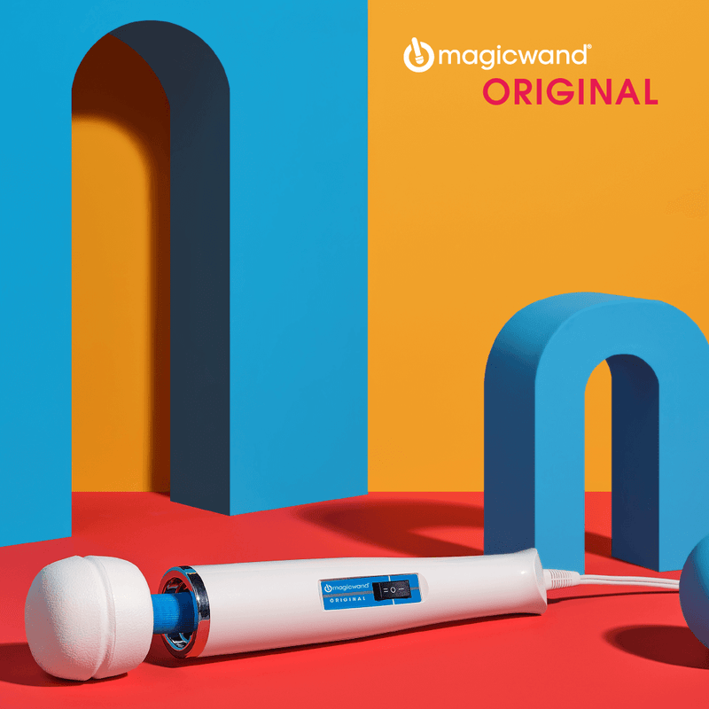 Square image. The Magic Wand sits on a red floor. Tall, blue geometric shapes surround the wand on multiple sides, and the wall of the image is a bright orange. | Kinkly Shop