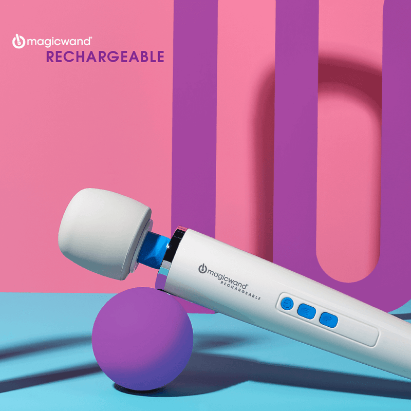 Square image of the Vibratex Magic Wand Rechargeable. The massager is tilted upwards with the handle balancing precariously on a purple ball. The pink background contrasts with the blue and white of the wand massager. Purple, contrasting, geometric shapes are in the background of the image.  | Kinkly Shop