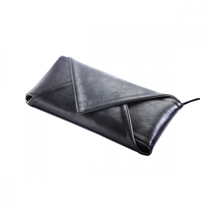 The WARM Sex Toy Warmer completely closed up. The vegan leather looks shiny and gorgeous, and the entire thing looks like a plushy, black envelope - or a luxury clutch purse. A cord sticks out of the corner of one of the folded edges of the WARM (the power cord) | Kinkly Shop