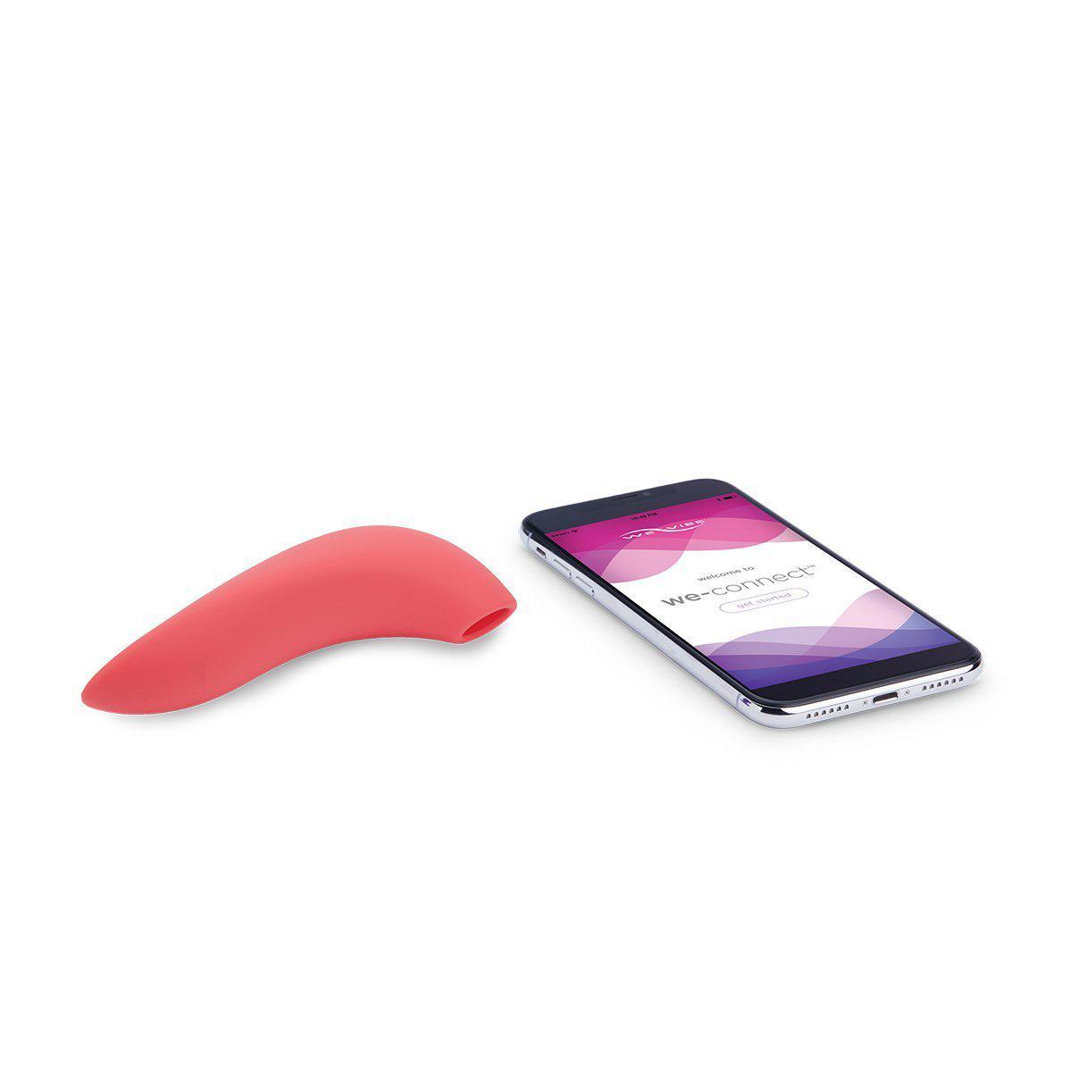 The We-Vibe Melt sitting out next to a cell phone. The cell phone is turned on and displaying the home screen for the We-Connect app to pair with the Melt. The Melt is surprisingly small and even shorter and thinner than a cell phone. | Kinkly Shop