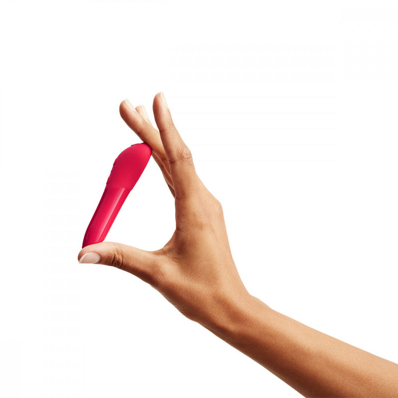 A hand holding the We-Vibe Tango X to show the small size of the pink bullet vibrator | Kinkly Shop