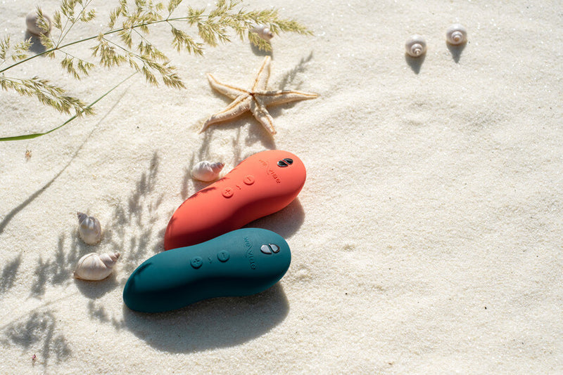 Both colors of the We-Vibe Touch X laying out on a beach. | Kinkly Shop