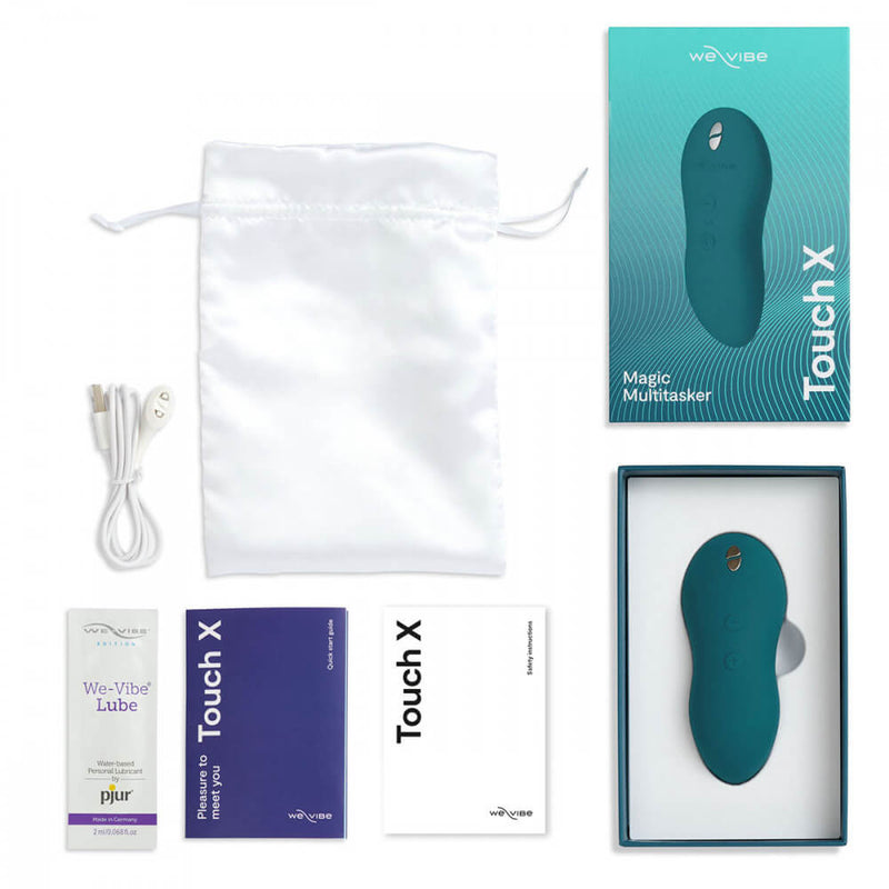 Top-down view of all of the items that come with the We-Vibe Touch X. It showcases the packaging, the white drawstring bag, the magnetic charging cable, the sample-size packet of lube, the instruction manual, and the We-Vibe Touch X vibrator itself. | Kinkly Shop