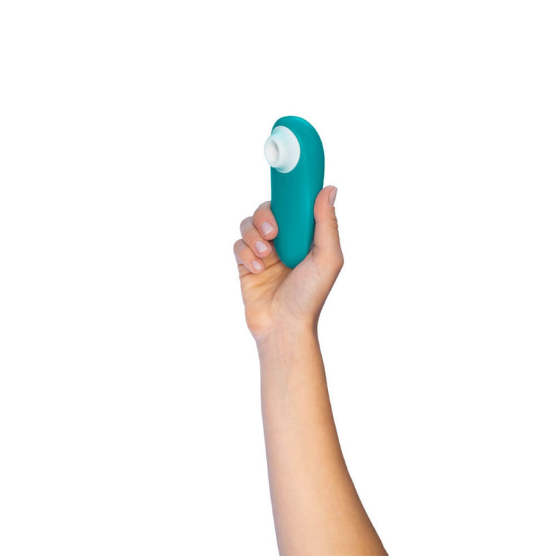 A hand holds the Womanizer Starlet 3 up in the air. This showcases the very small size of the Starlet 3. It is likely shorter in height than the person's fingertips to the base of their palm. | Kinkly Shop
