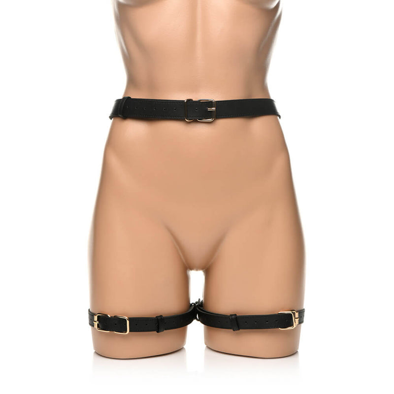A mannequin wears the Strict Bondage Harness with Bows in black. This is the front of the doll. There is one strap wrapped around the mannequin's waist and two straps wrapped around the thighs. It looks more complicated from behind, but the front side is much simpler. | Kinkly Shop